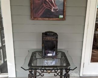 Nice wrought iron outdoor table, with glass top and "Moo Moo Becky Sue" framed cow painting and vintage tin/glass coffee tin.