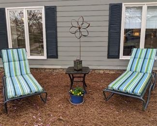Yard art for your pleasure - pair of comfy lounge chairs, matching side table, glazed terra cotta planter with violas and rusty ol' windmill.