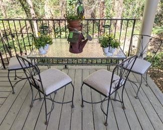 Wonderful vintage wrought iron/glass patio set, with textured glass top, four matching chairs, pair of tin planters with fresh violas, painted tin watering can birdhouse and pair of green tin pillar candle holders. 