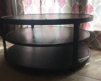 Tiered hammered metal table with faux leather top.  Castor wheels, 