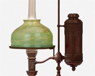 3
A Tiffany Studios Single-Arm Student Lamp
1902; New York, NY
Shade bares signature: L.C.T.; Base marked: 25564
The green and blue iridescent Tiffany-style glass shade on a Gothic-style patinated bronze Manhattan Brass Co. converted oil lamp base with oil canister and glass hurricane chimney, decorated with elliptical twisted wire designs and beaded trims, electrified
Overall: 23.5" H x 15.5" W x 10.5" D; Shade: 10" Dia.
Estimate: $2,000 - $3,000