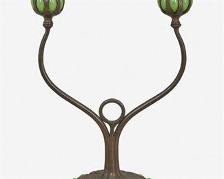 14
A Tiffany Studios Double-Arm Bronze Candlestick
Circa 1900-1902; New York, NY
Signed: Tiffany Studios / New York / [T.G.D.Co. monogram]
The patinated bronze candlestick with floral motif base and inset green Favrile glass cabochons issuing two curved arms terminating in green blown Favrile glass capitals with removable bobeches
12.875" H x 8.75" W x 5.5" D
Estimate: $1,000 - $2,000