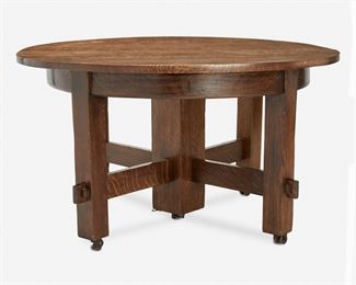 41
A Gustav Stickley Extendable Oak Dining Table
Circa 1901
Appears unsigned
The extendable oak dining table with round top over a split-pedestal base with central column and four square legs joined by a keyed mortise and tenon X-stretcher raised on castors, with three custom leaves and leather table cover
30" H x 53.5" Dia.; Extended: 101.5" W x 53.5" D
Estimate: $2,000 - $3,000