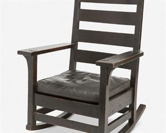 40
A Gustav Stickley Fumed Oak Rocking Chair, No. 315
First-quarter 20th Century; Eastwood, NY
Appears unsigned
Designed 1904, the original finish fumed oak ladder back rocking chair with four back cross rails and corbeled arms over a black leather seat atop four square legs with rockers joined by a box stretcher
38" H x 27.25" W x 28" D
Estimate: $800 - $1,200