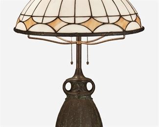 60
An Arts And Crafts Leaded Glass Table Lamp
First-quarter 20th Century
The domical leaded slag glass shade with white panels and caramel-colored lozenge bands on a two-light verdigris patinated bronze base with two acorn pulls and a bulbous tapered body decorated with low relief floral motifs and two stylized loop handles, electrified
Overall: 24" H x 19" Dia.
Estimate: $500 - $700