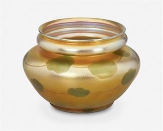 75
A L.C. Tiffany Favrile Glass Leaf And Vine Vase
1910; New York, NY
Signed: L.C. Tiffany / Favrile / 376 E
The gold iridescent Favrile glass vase with green iridescent leaf and vine motif, wide mouth, pinched neck, and wide-shouldered body
4" H x 6.25" Dia.
Estimate: $600 - $800