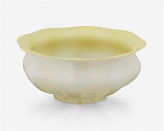 81
A L.C. Tiffany Yellow Opalescent Favrile Glass Bowl
First-quarter 20th Century; New York, NY
Signed: [L.C.T. monogram paper label]
The Favrile glass bowl with yellow scalloped and flared onion skin rim with white underside transitioning to translucent glass with opaque opalescent triangular panels on an octagonal body
3.5" H x 8.125" Dia.
Estimate: $400 - $600