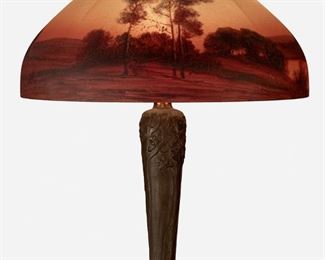 90
A Handel Reverse-Painted Glass Landscape Table Lamp
First-quarter 20th Century; Meriden, Connecticut
Shade signed: Handel / 7104; Base signed: Handel
The domical, chipped ice finished glass shade molded with eight vertical lobes and with reverse-painted wooded lakeside scene during a red and yellow sunset with birds in flight on a three-light patinated metal tapered base with low relief trees and roots extending over a circular foot, electrified
Overall: 23" H x 18" Dia.
Estimate: $1,000 - $1,500