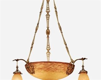 132
A Muller Frères Art Glass Chandelier
Second-quarter 20th Century; Luneville, France
Signed: Muller Freres Luneville
The six-light chandelier with a mottled purple and orange frosted glass bowl mounted with gilt-brass filigree arms terminating in drop pendant lights with matching glass shades and fitted with a gilt-bronze floral motif harness and foliate canopy, electrified
37" H x 22" Dia.
Estimate: $600 - $800