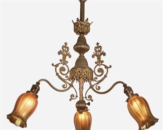 134
A Victorian-Style Chandelier With Steuben Aurene Glass Shades
First-quarter 20th Century
Each shade signed: Steuben
The gilt-metal chandelier with reeded and knopped column, openwork foliate bobeche and gallery, and ball finial issuing three arms with scrolling foliate arm backs, each terminating in an iridescent gold Steuben Aurene glass floriform shade, electrified
32" H x 28" Dia.
Estimate: $600 - $800