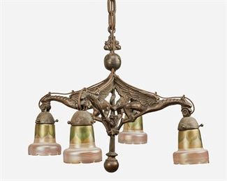 146
An Art Nouveau Bronze Dragon Chandelier
First-quarter 20th Century
Each shade signed: Quezal
The patinated bronze four-light chandelier issuing four zoomorphic dragon arms, each terminating in an iridescent gold Quezal glass shade with green pulled feather motif, white spun overlay, and scalloped rim, fitted with original suspended chain link harness, canopy, and ball finials, electrified
50" H x 24" Dia.
Estimate: $800 - $1,200