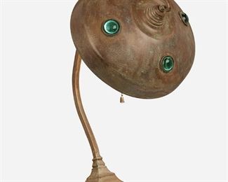 150
An Art Nouveau Austrian Brass Table Lamp
First-quarter 20th Century; Austria
The brass table lamp with a shallow domed shade inset with four green jeweled cabochons angled atop a curving slender stem on a squared foot, electrified
17" H x 9.5" W x 11" D
Estimate: $400 - $600