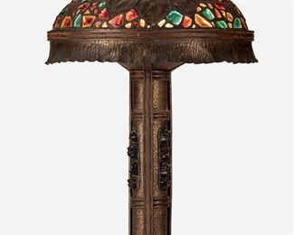 151
An Art Nouveau Austrian Chunk Glass Table Lamp
First-quarter 20th Century; Austria
The bronze table lamp with dome shade with green, red, and yellow glass jewels, hammered floral motif, and ruffled skirt on a cylindrical column with inset glass jewels raised on three coiled feet, electrified
Overall: 30" H x 19" Dia.
Estimate: $800 - $1,200