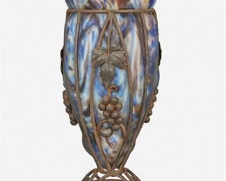 155
A Charles Schneider Le Verre Français Wrought Iron And Glass Vase
Circa 1918-1932; Epinay-sur-Seine, France
Signed: Le Verre Francais [Croix de Lorraine]
The Art Deco tapered vase with mottled blue and purple cased glass blown in a wrought iron cage with grapevine motif raised on a circular wrought iron foot with swirls
14" H x 7" Dia.
Estimate: $500 - $700