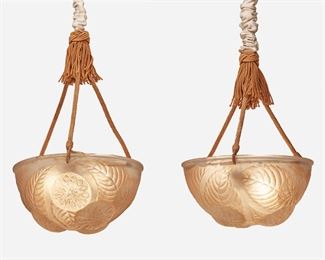 172
A Pair Of R. Lalique Frosted Glass "Dahlias" Chandeliers
Circa 1921
Each signed: R. Lalique / France
Designed 1921, model no. 2459, each chandelier with a frosted glass globular shade with pressed dahlia motif and copper-colored highlights fitted with three light sockets and a three-rope mount with central tassel, electrified, 2 pieces
Each shade: 5.625" H x 12" Dia.
Estimate: $800 - $1,200