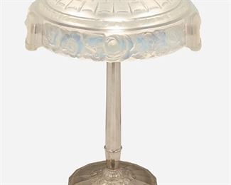175
A Sabino Art Deco Glass Table Lamp
Second-quarter 20th Century
Shade signed: Sabino / 4330 / BIS / Paris / Depose
The shallow domed, semi-transparent opalescent glass shade with a basketweave-style top over a foliate garland trim and band of modeled flowers atop a three-light silvered metal base with rosette motif, electrified
Overall: 22.5" H x 17.75" Dia.
Estimate: $800 - $1,200