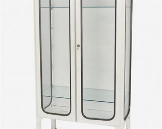226
A White Metal Medical Cabinet
Second-quarter 20th Century
The white painted metal cabinet with two doors, four rectangular glass panels with rounded corners and black trim fitted with three glass shelves raised overall on four square feet
71" H x 39.25" W x 18.5" D
Estimate: $600 - $800