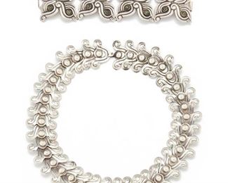 256
Two Los Castillo Silver Jewelry Pieces
1940, Taxco, Mexico
Stamped: Los Castillo Sterling / Made in Mexico / Sterling / 262
Comprising a necklace designed with stylized curls with ball joints, with hook and eye closure, further marked: 262, and a bracelet designed with four quatrefoil panels set with cabochon green turquoise, further stamped: 122, 2 pieces
Necklace: 18" L x 1.50" H; Bracelet: (6.50" L x 1.50" H)
222 grams
Estimate: $800 - $1,200