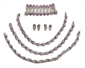 257
A Set Of Los Castillo Silver And Amethyst Jewelry
1939-1945 and 1945-1960; Taxco, Mexico
Each stamped: Los Castillo / Eagle 15; Each variously stamped: Made in Mexico / Taxco / Sterling / 468 / 372 / Silver / Mexico
Comprising a necklace (17" L x .5" H) set with amethyst cabochons with matching bracelet (6.5" L x 2" H) and a pair of screw-back earrings (1.125" H x .5" W), 4 pieces
171.7 grams
Estimate: $1,000 - $2,000