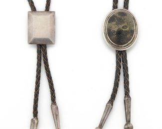 275
Two Hector Aguilar Bolos
1955-1962; Taxco, Mexico
Each stamped: Taller Borda / Taxco / Mexico / .940 / Eagle 9
Cpmprising one stone set and one square beveled bolo, each attached to braided leather, 2 pieces
Bolo with stone: 1.75" H x 1.18" W; Silver bolo: 1.25" H x 1" W
72 grams gross
Estimate: $200 - $400