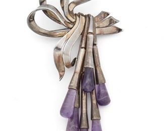 277
An Antonio Pineda Amethyst Brooch
1953-1979; Taxco, Mexico
Crown mark for Antonio Pineda; eagle 17; Further stamped: Hecho en Mexico / PR527
Designed as a stylized ribbon brooch suspending trumpet-form dangles tipped with amethyst drops
4.50" L x 2.50" W
59.9 grams
Estimate: $500 - $700