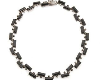 282
An Antonio Pineda Silver And Onyx Necklace
1953-1979; Taxco, Mexico
Crown mark for Antonio Pineda; Further stamped: Eagle 17 / 970
The geometric-link necklace set with carved onyx half-cylinders
14.5" L x .5" H
55.5 grams
Estimate: $500 - $700