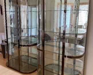 Beautiful Contemporary Curved Glass Display Cabinet from Gabbert's. Sleek contemporary design- A beautiful glass and nickel plated curio cabinet.   Front glass cabinet with four interior generous sized glass shelves. Curved sides and lighted top to showcase your treasures.  Beautiful gray and chrome detailing. 
Measurements; 78" h x 42" w x 19" d