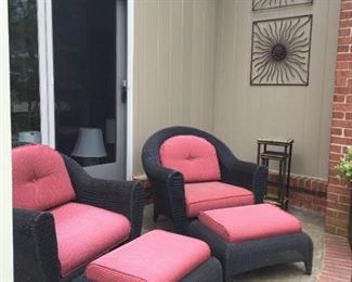 Three-piece black wicker set with cushions, plus Metal wall hangings.