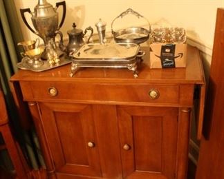 small buffet/bar with drop leaf sides, assorted silver serving pieces