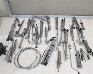 FOLDED MUSIC STANDS AND SEVERAL DRUM PEDALS.