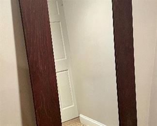 Tall mirror with brown frame by parallel lines