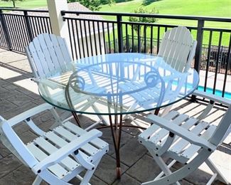 Iron base glass top table measures 48" in diameter. White chairs are SOLD.