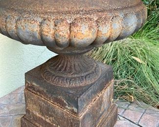 PAIR OF URNS AVAILABLE                                              Antique cast iron urns atop a pedestal base. Each urn measures 21" x 29". Each pedestal measures 12" high bringing the overall height to 33"