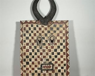 ETHNOGRAPHIC CARVED MASK PANEL | with raised red and white checks, horns, h. 43 x 24 in. 