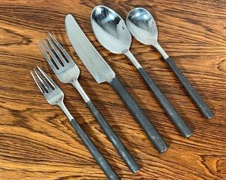 HAND MADE STEEL FLATWARE SERVICE | each piece hand hammered and formed from a single sheet of metal, comprising; 13 dinner forks, 14 dinner knives, 13 tablespoons, 11 salad forks, 9 teaspoons, plus three serving forks and three serving spoons, truly unique and beautifully crafted 