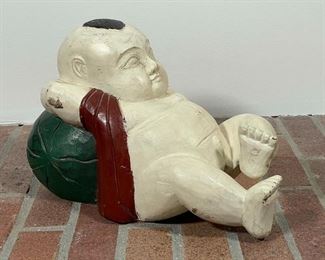 CARVED PAINTED JAPANESE FIGURE | showing a boy reclining on a watermelon; h. 10 x 14 x 9 in. 