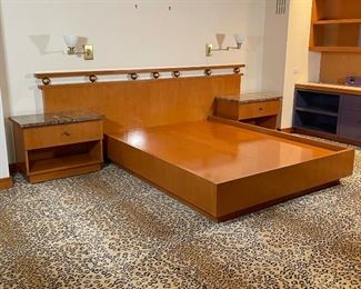 MARBLE NEW WAVE BED & CABINETS | a custom build platform for a queen bed joined to an oversized headboard with gilt spheres, matching single-drawer stands with highly figured stone tops; cabinets on wheels and separate from headboard, could be used on their own - really amazing stone some of the best we've seen... 