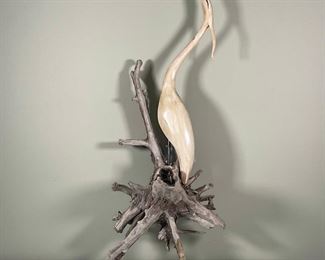 CARVED EGRET SCULPTURE | carved and polychrome decorated egret sculpture mounted on a post on an old stump; appears to need to lean on something for egret to be upright; h. 43 x 19 x 12 in.; [egret only: h. 29 in.)
