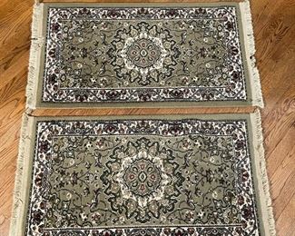 PAIR WOOL RUGS | each with a green/ gray ground and a central sculpted medallion; 3ft-4in x 1ft-11in.