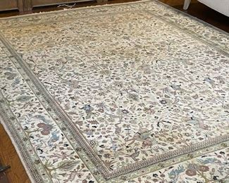 PERSIAN STYLE CARPET | with figures engaged in activites, horses, birds, deer and hunters; blue pattern over a cream field; 12ft-3in x 8ft-8in.