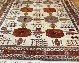 CAUCASIAN STYLE GEOMETRIC CARPET | eight medallioins in various colors on a cream field with a rust border; 12ft x 9ft