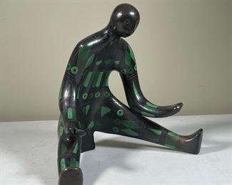 CARVED POLYCHROME SEATED FIGURE | decorated with etched painted geometric shapes, h. 12 x 13 x 10 in.
