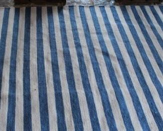 Blue and white striped rug is 5 ft by 7 ft.  $75.00.          This item is at the West location. 