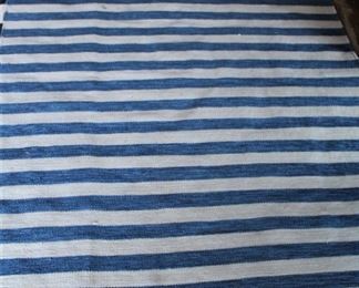 Blue and white striped rug is 5 ft by 7 ft.  $75.00.          
This item is at the West location.