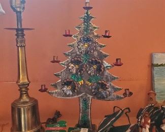 Pressed tin tree with candle holders at ends of branches.