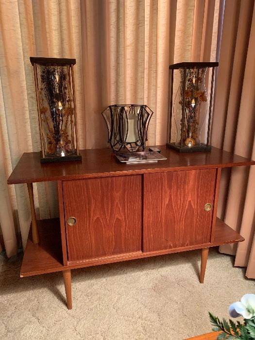 BID ITEM:-  MCM  cabinet with sliding doors, Made in Yugoslavia(fits LP records) W: 40", H: 26" D: 18" Pair wood carved hurricanes with dried flowers (sold individually) Luminara glass centerpiece with battery controlled candle and remote.