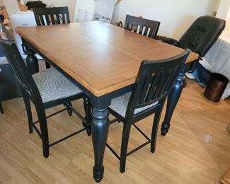 200.00, cherry and black enamel high top table with 8 chairs and one leave. 54 x 40 x 36"tall. VG condition except wear to finish on edge as shown.