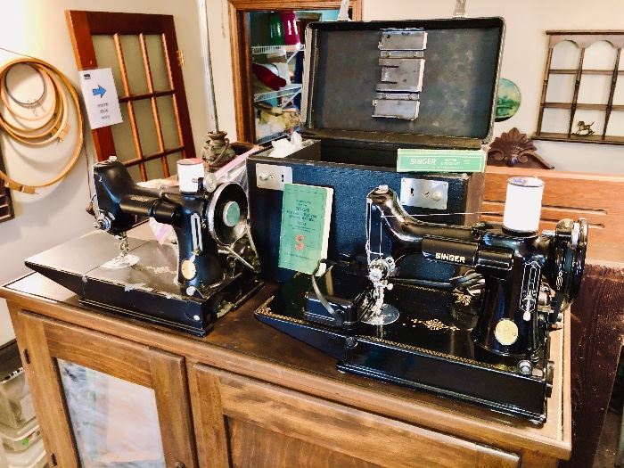 TWO Singer Featherweight sewing machines!  Model 221-1.  The unit on the right comes complete with case, manual, lubricant, foot pedal and other accessories.  The left unit comes with only its foot pedal.