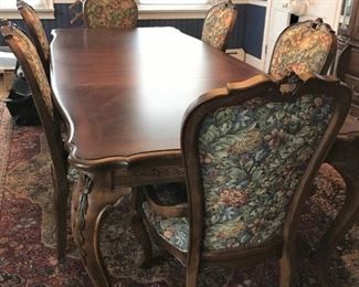 Antique-look dining table with 2 upholstered captain chairs, and 4 upholstered side chairs.  Includes 2 leaves (18" wide each) and wood-grained flocked custom-made pads. Table measures 70" long, 30" high, 43" wide.  
