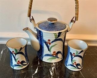 $50 - Tea set with pot and two cups; 9 in. H teapot with handle up x 7 1/2 in. W. Each cup is 3 in. H
